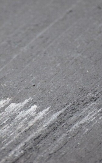 Nahaufnahme einer Sichtbetonoberfläche mit feiner, glatter Struktur. Die Oberfläche zeigt leichte Schlieren und dezente Farbunterschiede, die von der Verarbeitung und dem Ausschalen stammen. Typisch für Sichtbeton sind die sichtbaren Bearbeitungsspuren, die dem Material eine moderne, puristische und handwerkliche Anmutung verleihen.

                                    